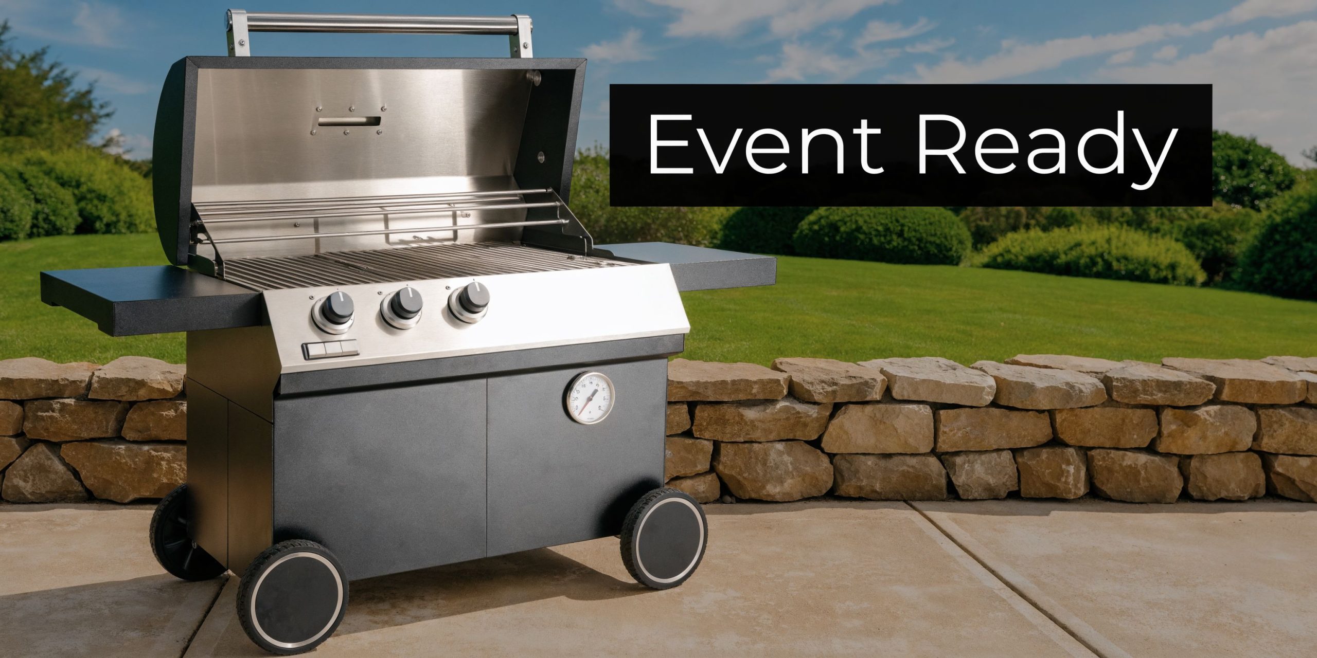 A modern three-burner gas braai grill stands on a patio with a stone wall in the background.