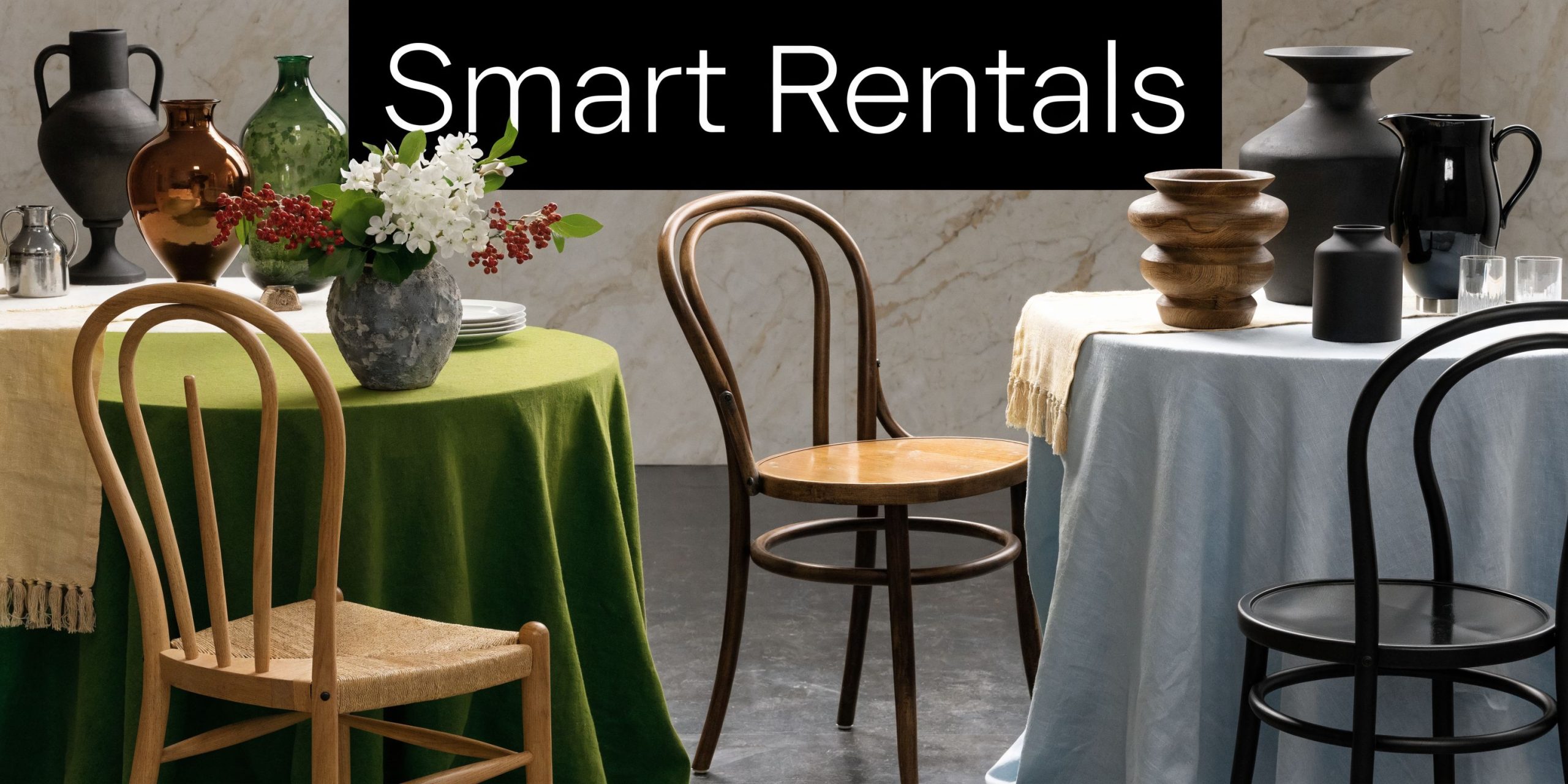 A sophisticated dining setting featuring two tables with green and light blue tablecloths, decorative vases, and chairs.