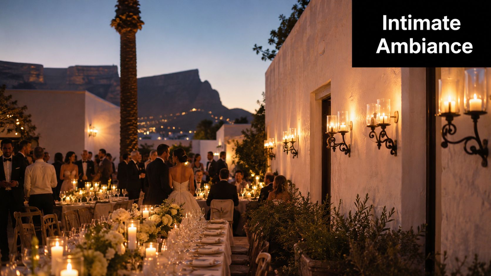 Elegant wedding dinner party with candle wall holders creating an intimate ambiance under a sunset mountain view.